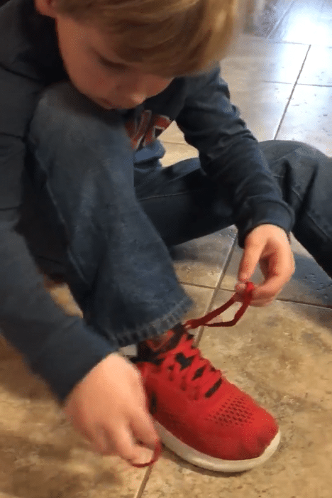 Enfant faisant lui-même ses lacets